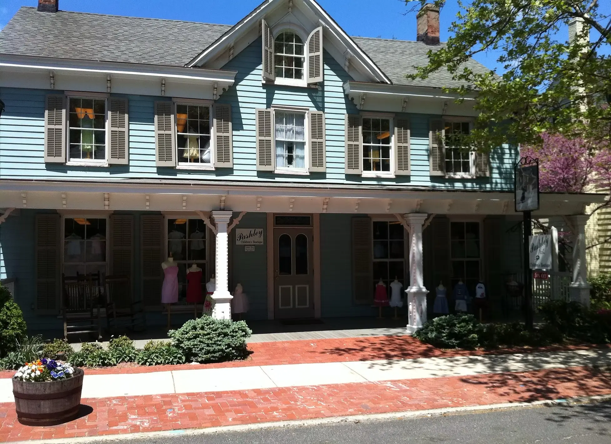 Pashley Children's Boutique, a light blue two-story Victorian house on Main Street with children's outfits displayed in the porch windows.